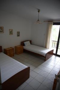 ein Schlafzimmer mit zwei Betten und einem Fenster in der Unterkunft Seaside Vila in Platanitis
