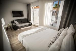 a bedroom with a bed and a couch and a window at Villa Jandia Luxury Bungalow in Morro del Jable