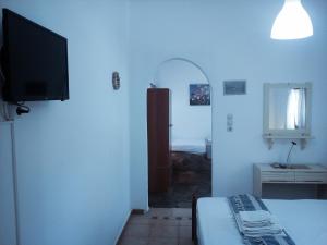 PaliochoriにあるMar-Nik Villageのベッドルーム1室(ベッド1台、壁掛けテレビ付)