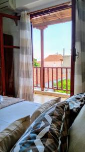 a bedroom with a bed and a large window at ILAIRA in Skala Eresou