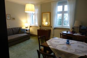 a living room with a table and a couch and a dining room at Pension Gräfliche Villa in Reitwein