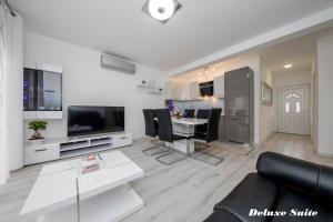 a living room with a couch and a dining room at Villa Harmony Rab in Barbat na Rabu
