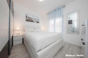 a white bedroom with a white bed and a window at Villa Harmony Rab in Barbat na Rabu +55 photos
