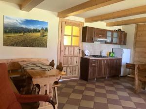 a kitchen with a table and a refrigerator and a table at Pokoje Gościnne U Jaśka in Ząb