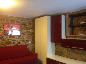 a living room with a red couch and a window at Accogliente monolocale in Isola del Giglio