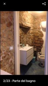 a bathroom with a sink and a stone wall at Accogliente monolocale in Isola del Giglio