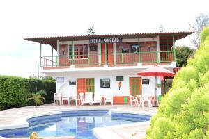 uma casa com piscina em frente a um edifício em Finca Hotel Villa Soledad em Quimbaya