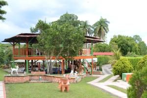 un edificio in un parco con parco giochi di Finca Hotel Villa Soledad a Quimbaya