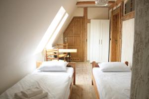 Duas camas num pequeno quarto com uma mesa em Karczma Bełty em Glinno
