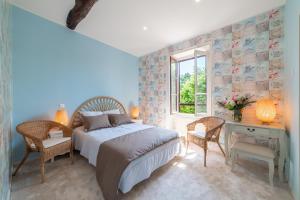 a bedroom with a bed and a desk and a window at Hôtel Au Coq Dort Spa in Châtillon-sur-Chalaronne