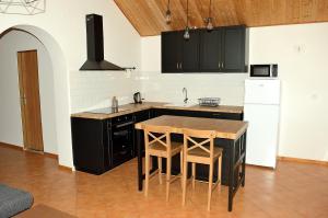 cocina con armarios negros y mesa de madera en Apartmán s vinným sklepem Four Grapes, en Jevišovka