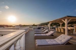 a row of lounge chairs on the roof of a building at Villa Harmony Rab in Barbat na Rabu