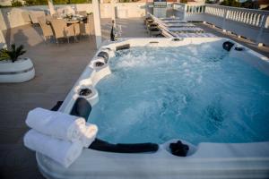 a jacuzzi tub on a patio with towels at Villa Harmony Rab in Barbat na Rabu