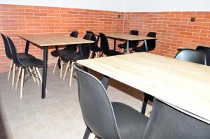 rząd drewnianych stołów i krzeseł w pokoju w obiekcie Apartmán s vinným sklepem Four Grapes w mieście Jevišovka