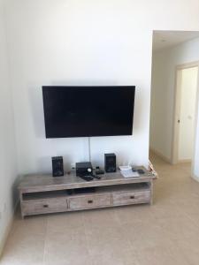 a flat screen tv on top of a wooden entertainment center at Villa Blue Horizon in Playa Blanca