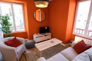 uma sala de estar com dois sofás brancos e uma televisão em Gahenda - Appartement Volumineux et Familial - Parking, WiFi & Netflix em Hendaye