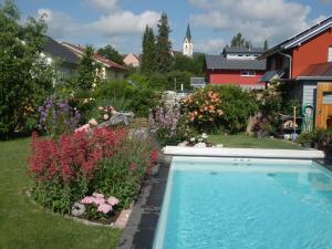 una piscina en un jardín con flores en Bed & Breakfast Engen, en Engen