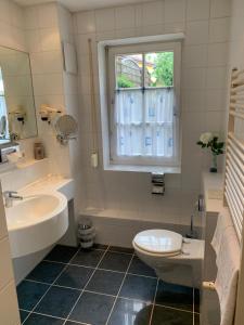 uma casa de banho com um lavatório, um WC e uma janela. em Hotel Zwei Länder em Apolda
