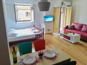 a living room with a bed and a table and chairs at Apartment Maris in Ohrid