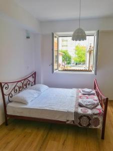 Bett in einem Zimmer mit einem Fenster und einem Bett sidx sidx sidx sidx in der Unterkunft Apartment Maris in Ohrid