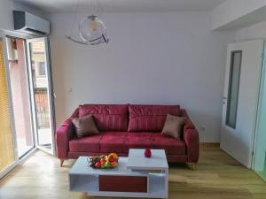 ein Wohnzimmer mit einem roten Sofa und einem Tisch in der Unterkunft Apartment Maris in Ohrid