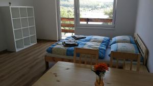 1 dormitorio con cama, mesa y ventana en Apartmány Orlík - Loužek en Milešov