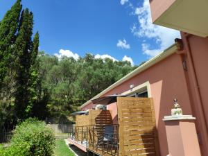 eine Terrasse mit einem Tisch und einem Sonnenschirm auf einem Haus in der Unterkunft ALONI CORFU BENITSES in Benitses