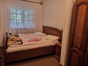 a bedroom with a bed with a dresser and a window at Floarea Reginei in Sâmbăta de Sus
