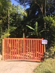 an orange gate with a sign in front of it at Flat Boa Vista in Paraty