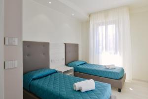 two beds in a room with blue walls at Residence Picalè in Alghero