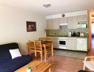 a kitchen and a living room with a couch and a table at Résidence les Crêtes in Torgon