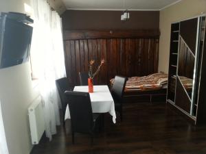 een kamer met een tafel en stoelen en een slaapkamer bij Pod Sarenką in Szczawnica