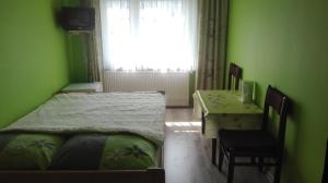 een slaapkamer met 2 bedden, een tafel en een raam bij Pod Sarenką in Szczawnica