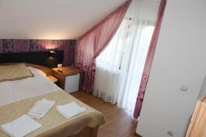 a bedroom with a bed and a large window at Perla Munților in Ranca