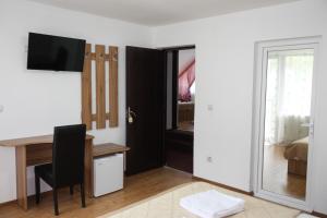 a room with a desk and a table with a mirror at Perla Munților in Ranca