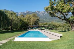 una piscina en un patio con una casa en Seehotel Ambach en Caldaro