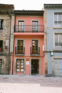 ein orangefarbenes Gebäude mit Fenstern und einem Balkon in der Unterkunft LA ATALAYA in Ribadesella
