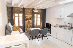 a kitchen and living room with white cabinets at LA ATALAYA in Ribadesella