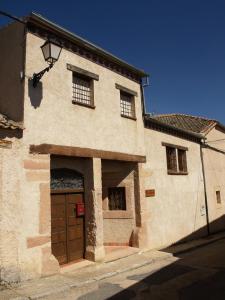 un edificio con una puerta marrón en una calle en Casa rural Callejón del Palacio, en Muñoveros