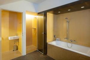 a bathroom with a tub and a shower and a tub at Alma Boutique-Hotel in Vienna