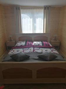 a bedroom with a bed with two pillows and a window at Pogodny Domek in Mielno