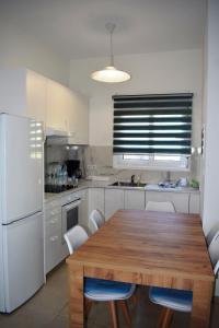 kuchnia z drewnianym stołem i białymi urządzeniami w obiekcie Villa Giovasia in Tolo w mieście Tolo