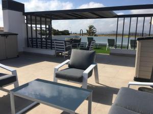 patio z krzesłami i stołem na dachu w obiekcie Mini Villa "Las Palmeras" w mieście Los Alcázares
