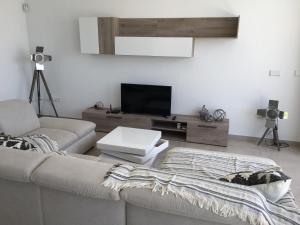 een woonkamer met een bank en een flatscreen-tv bij Mini Villa "Las Palmeras" in Los Alcázares