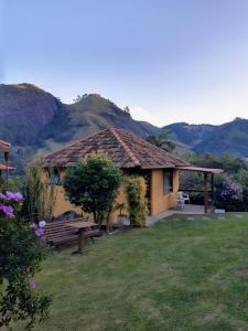 una casa con un banco en un patio con montañas en Chalés da Serra en São Pedro da Serra