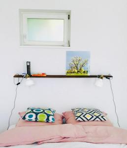 a shelf above a bed with pillows and a mirror at Alte Schlossgärtnerei in Plön