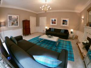 a living room with a couch and a table at Escape to Edinburgh @ Abercromby Place in Edinburgh