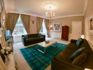 a living room with a couch and a table at Escape to Edinburgh @ Abercromby Place in Edinburgh