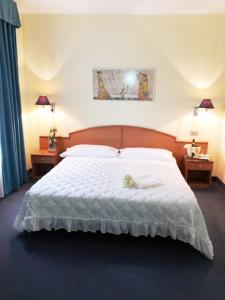 a bedroom with a bed with a stuffed animal on it at Europalace Hotel Todi in Todi +41 photos