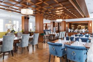 ein Esszimmer mit blauen Stühlen und Tischen in einem Restaurant in der Unterkunft Palace Art Hotel Pezinok in Pezinok